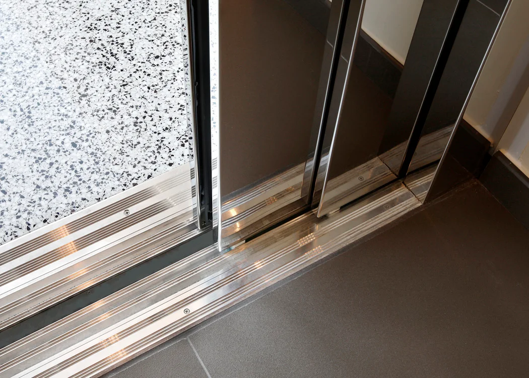 Cận cảnh ngưỡng và các rãnh dẫn cửa thang inox.