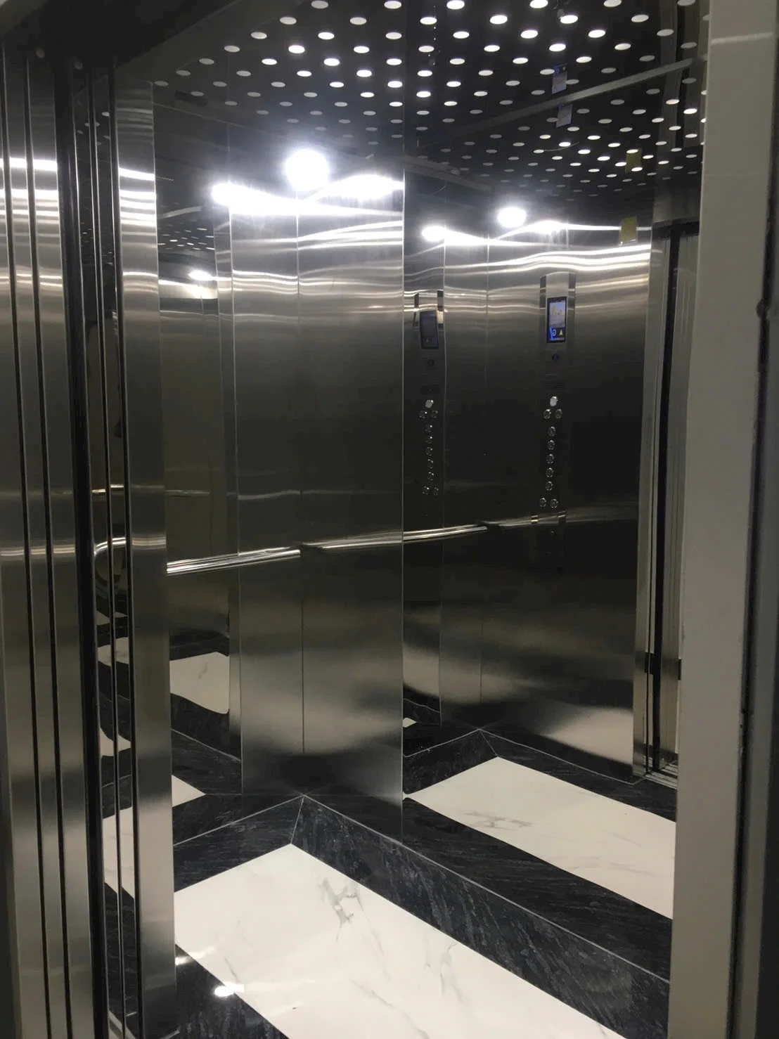 Nội thất cabin inox với trần chấm tròn và sàn đen trắng.